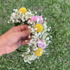 Handheld flower crown with white baby's breath, yellow blooms, and pink flowers