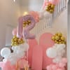 Pink and white balloon birthday display with a large number 12