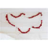 Red rose garland draped across a white headboard with a small cross pendant
