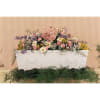 Large pastel floral arrangement in a white casket