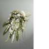White floral spray on a stand with a woven handle