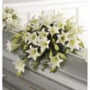 White lily funeral spray on a gray casket