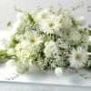 White floral casket spray with daisies and tulips