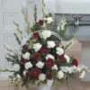 Red and white floral spray in a white easel frame
