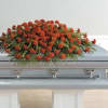 Red floral spray on top of a casket