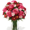 Pink roses and red daisy flowers in a clear glass vase
