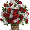 Red roses and white flowers arranged in a woven basket