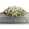 White floral casket spray with a silver casket