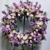 Large heart-shaped wreath of pink and purple flowers on an easel
