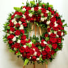 Large wreath of red roses and white carnations on a wooden easel