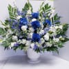 Blue and white floral arrangement in a white pedestal vase