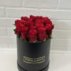 Red roses arranged in a black round box
