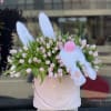 Pink tulips in a blush hatbox with a white plush bunny