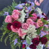 Bouquet of pink and burgundy roses with purple flowers and white filler