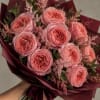 Bouquet of pink roses wrapped in burgundy paper