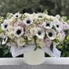 White and blush floral arrangement in a white vase