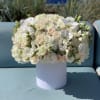 White floral arrangement in a round white vase
