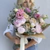 Large bouquet of pink and cream flowers wrapped in paper