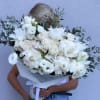 Large white bouquet of roses and lilies wrapped in paper