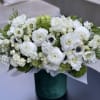 White floral arrangement in a green cylindrical vase