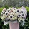 Blush and white floral arrangement in a pink hat box