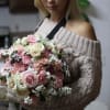 Woman holding a large bouquet of pink and white roses