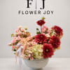 A sophisticated floral arrangement featuring soft pink roses, creamy hydrangeas, peach-toned accents