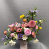 Mixed bouquet in a pink vase with pink, purple, white, and yellow flowers