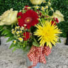 Mixed bouquet with red, yellow, and white flowers in a metal vase with a gingham ribbon