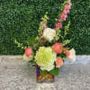 Mixed bouquet in a square glass vase with pink, white, and green blooms