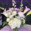 White floral arrangement with lilies and hydrangeas in a glass vase