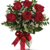 Red roses in a glass vase with a red ribbon