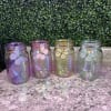 Four iridescent glass jars with butterfly decorations