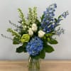 Blue and white floral arrangement in a clear glass vase