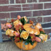 Pumpkin-shaped floral arrangement with yellow roses and orange daisies