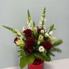 Red and white floral arrangement in a red glass vase