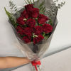 Bouquet of red roses wrapped in dark paper with a red ribbon