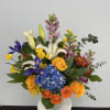 Colorful mixed bouquet with roses, lilies, hydrangea, and irises in a vase