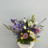 Purple and white mixed bouquet in a glass vase