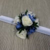 White rose corsage with blue flowers and a white ribbon