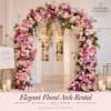 Pink and white floral arch framing a doorway with candles nearby