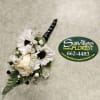 White floral boutonniere with daisies and a rose on a gray surface