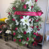 Standing floral spray with red roses and white lilies on an easel
