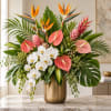 Tropical arrangement with white orchids, bird of paradise, and pink anthuriums in a gold vase