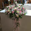 Large pink and white floral arrangement with trailing ribbon