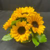Yellow sunflowers arranged in a low glass vase
