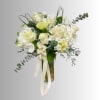White roses and hydrangeas in a glass vase with a cream ribbon