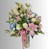 Mixed bouquet of roses, lilies, hydrangeas, and sunflowers in a tall vase