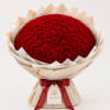 Large bouquet of red roses wrapped in beige paper with a red ribbon