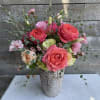 Pink and peach roses arranged in a decorative vase
